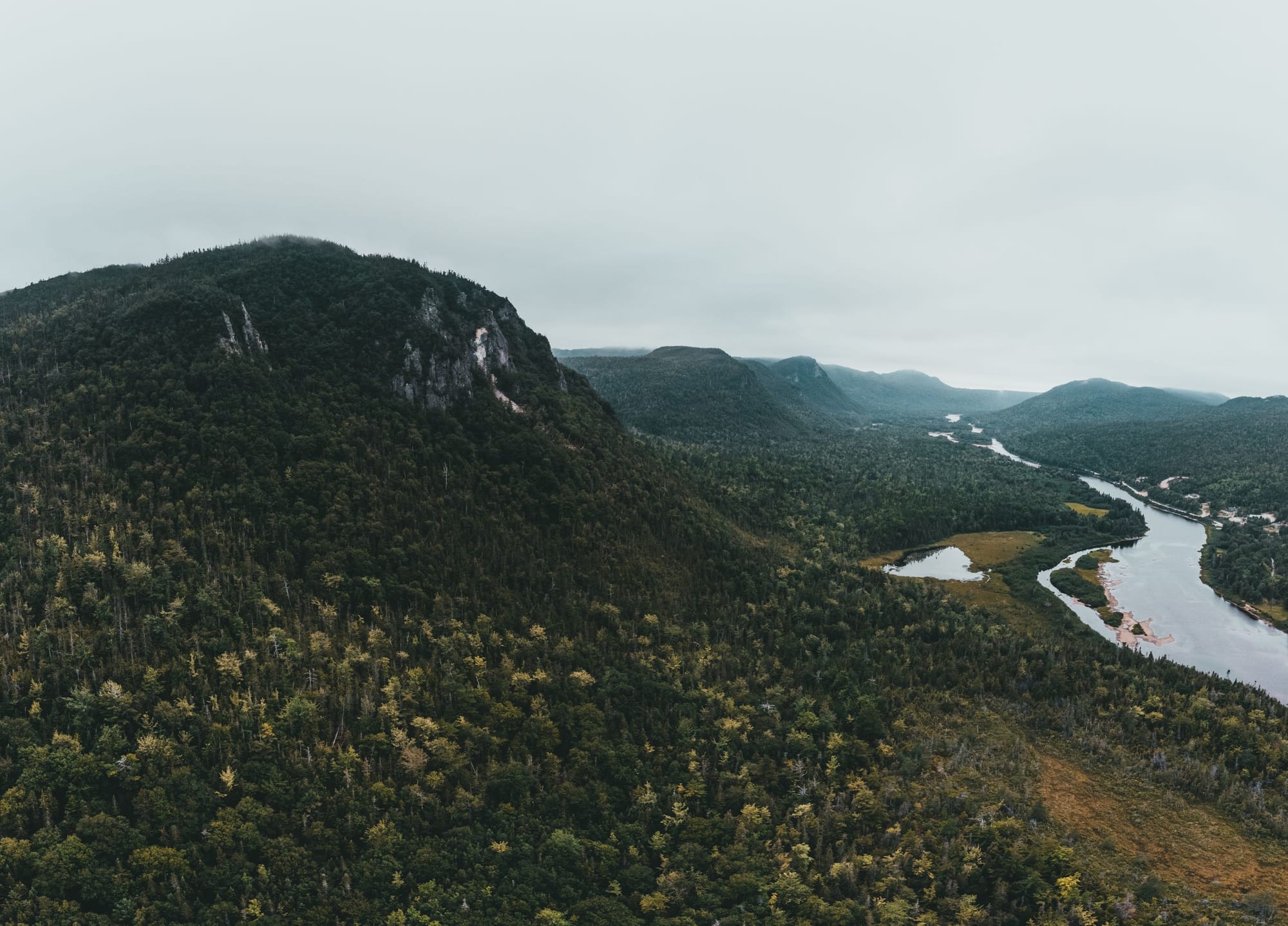 A river winding between fog-shrouded mountains